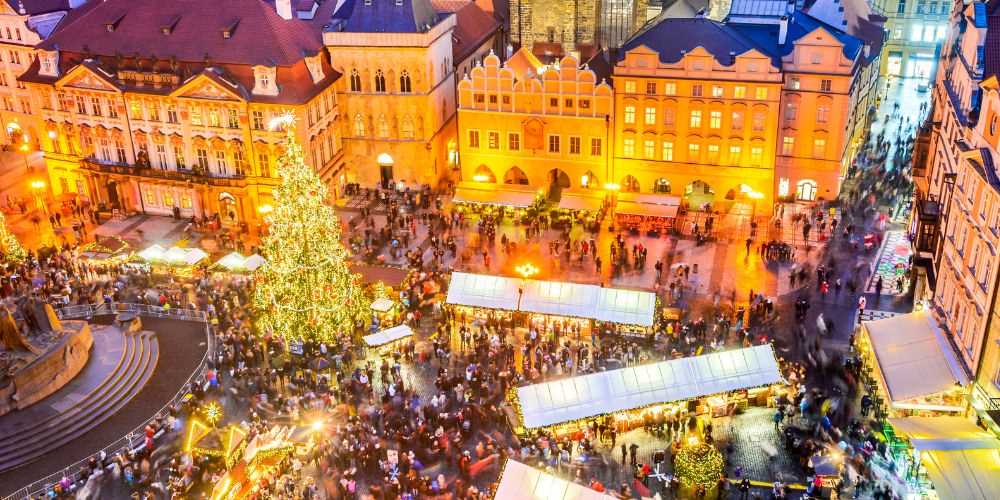 Top view of a crowded christmas market with a huge christmas tree beside the stage - best christmas markets in the world