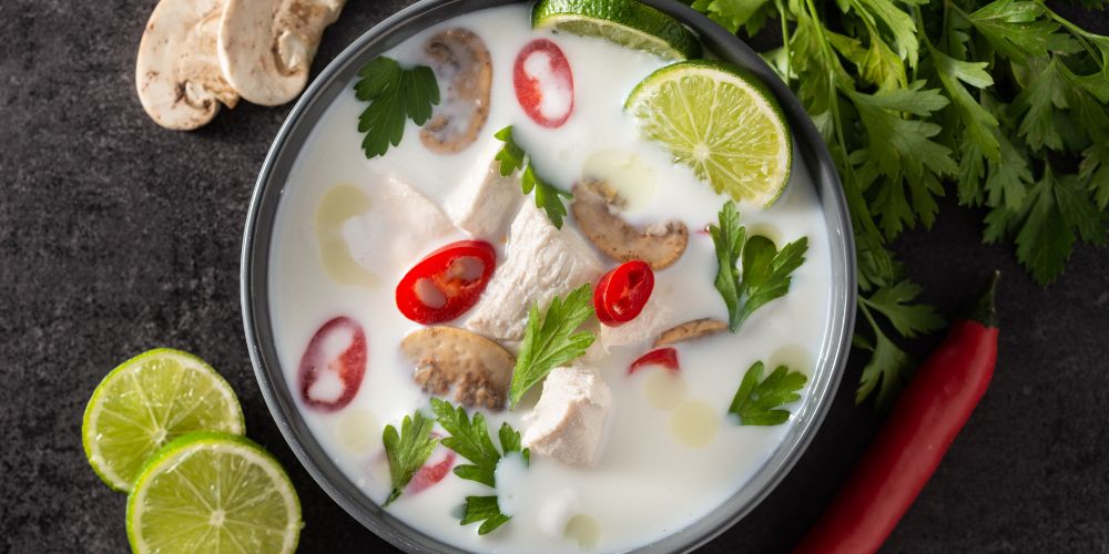 white soup with mushroom and green leaves on top - best thai food in thailand
