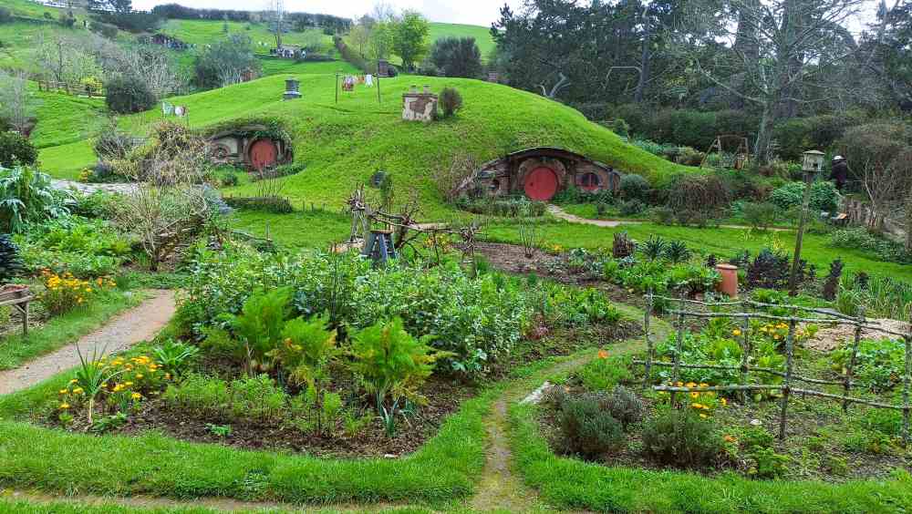 small hill with house in it and garden in front