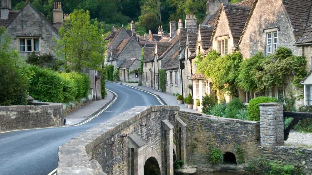 empty road surrounded by old structire houses- Best road trips in Europe