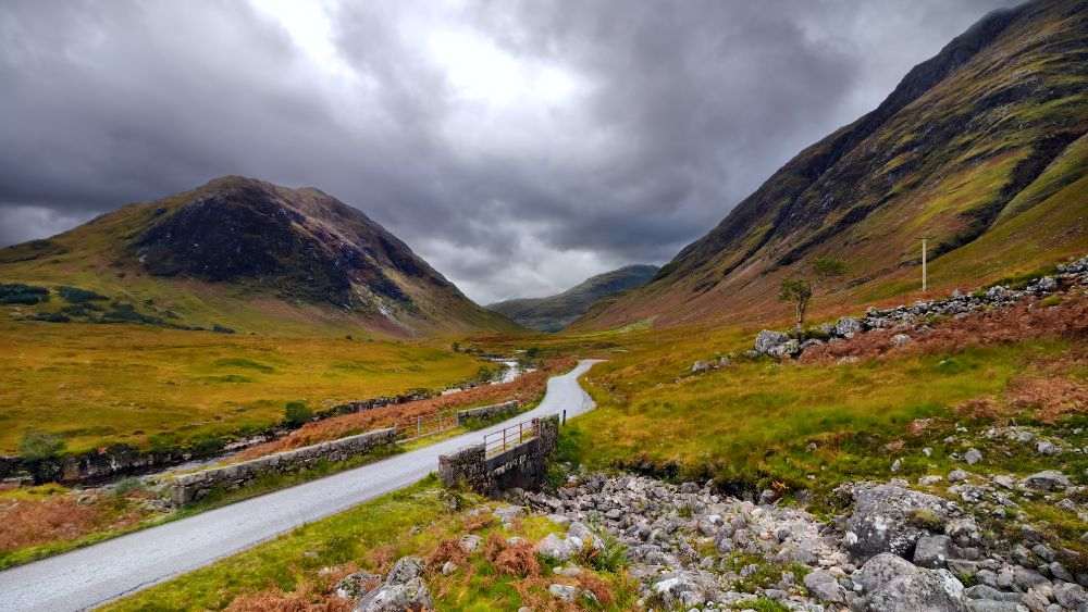 road in the middle of a lushy green hills- Best road trips in Europe