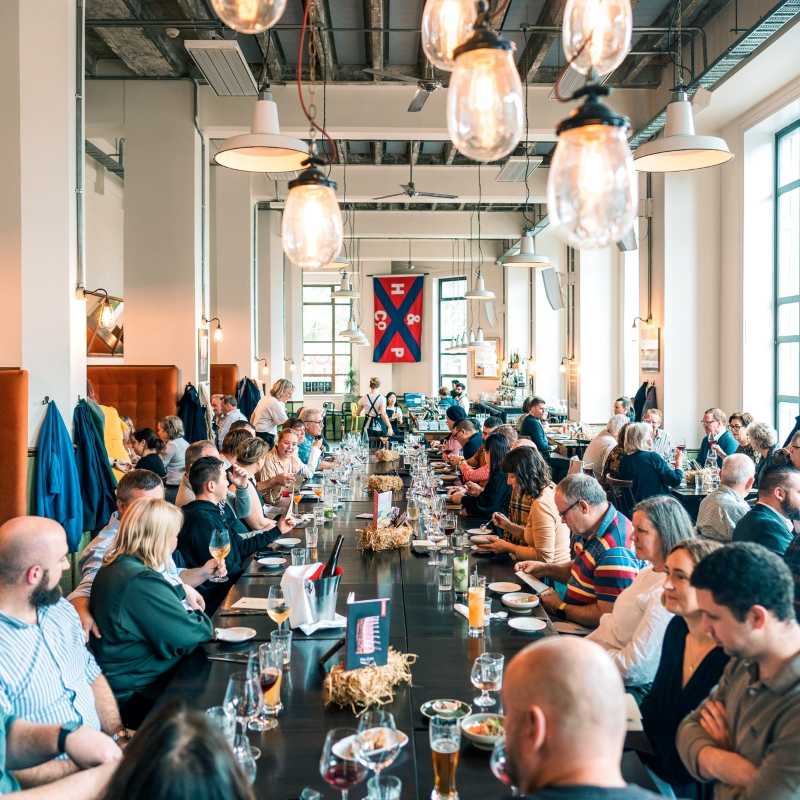 people sitting in front of long table eating - Things to do in New Zealand north island