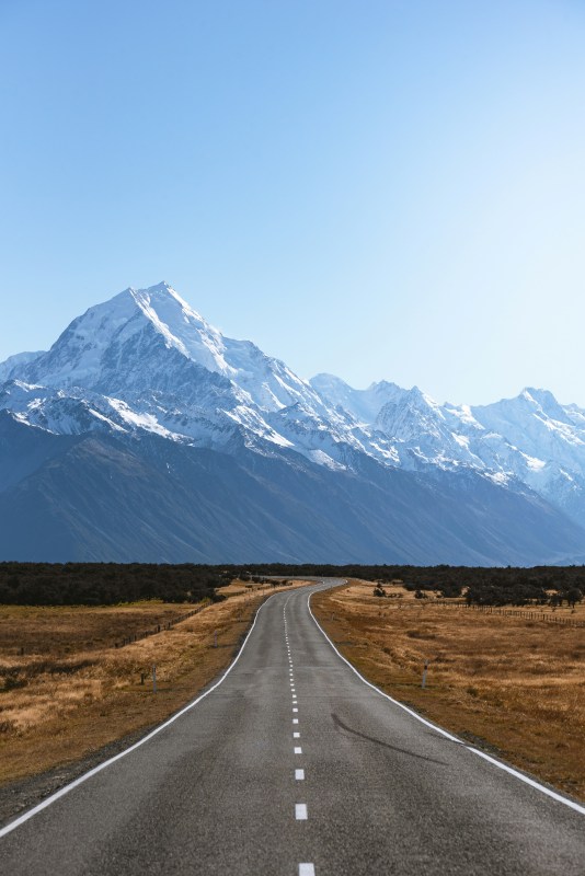 empty road going toward the mountain with ice on top
