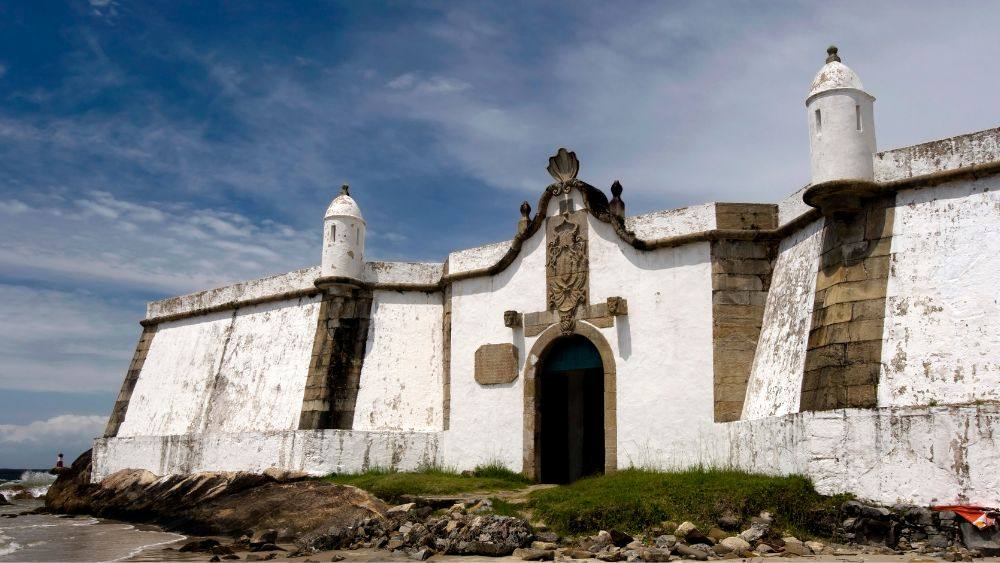 dirty white old building near the shore