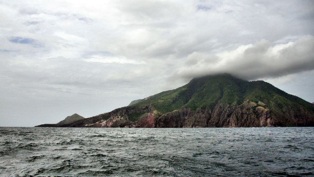 lushy green mountain surrounded by the ocean - Beautiful Islands